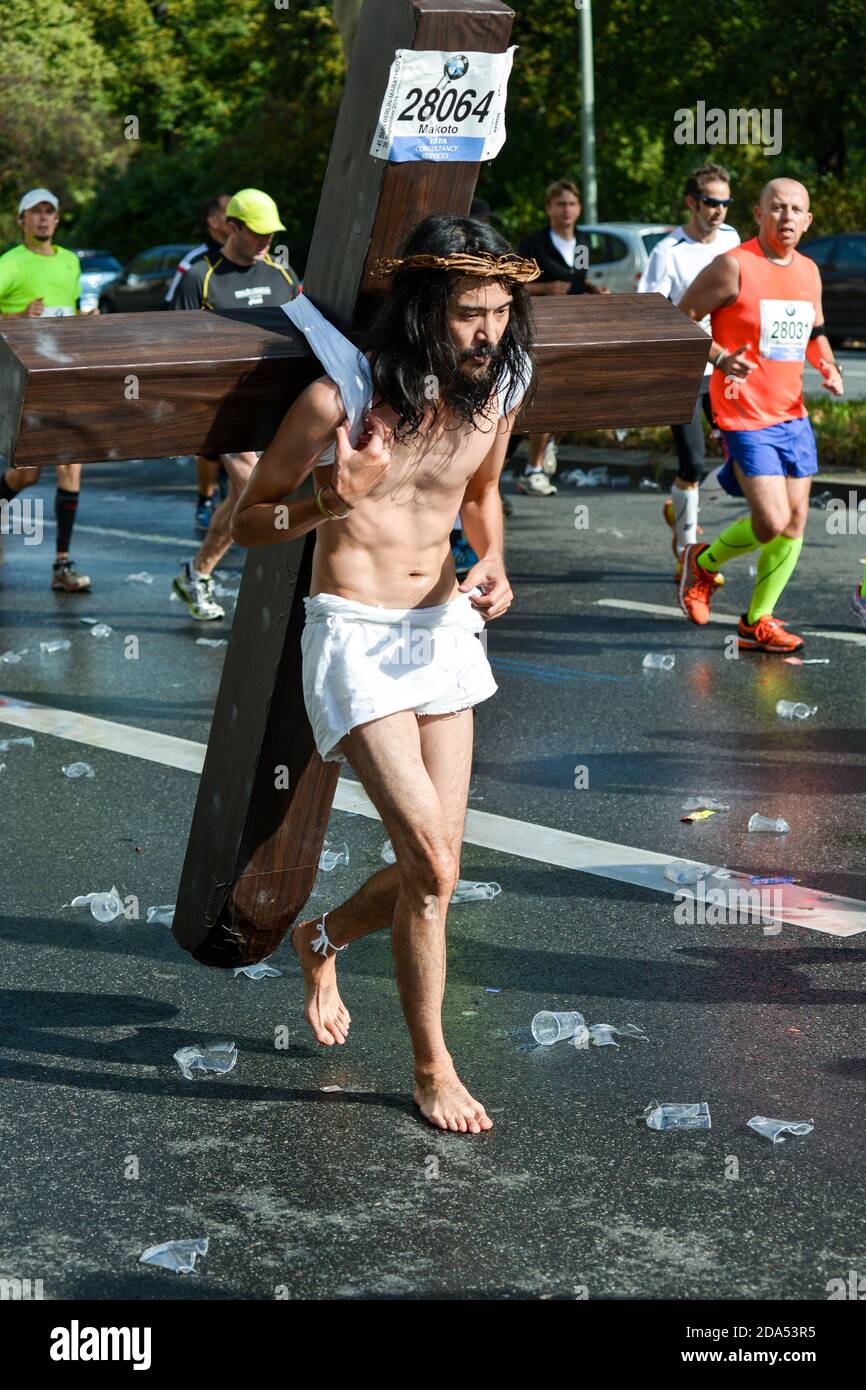 Jesus läuft: Ein japanischer Läufer beim Berliner Marathon 2014 führt eine Demonstration für den Weltfrieden durch und trägt ein Kreuz. Stockfoto