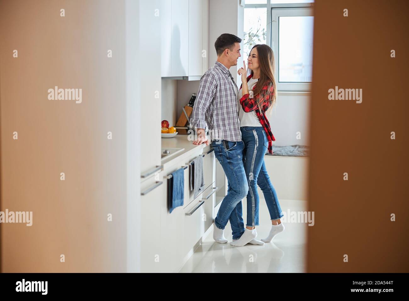 Schelmische Frau neckt ihren Mann in der Küche Stockfoto