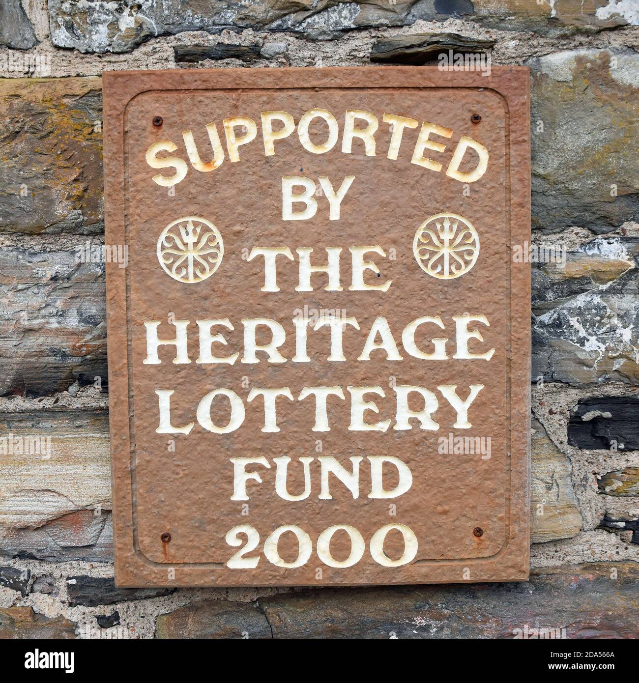 Isoliertes Schild, unterstützt vom Heritage Lottery Fund 2000, in Lybster, Caithness, Schottland. Braun und weiß Zeichen auf rustikalen Stein Wand. Stockfoto