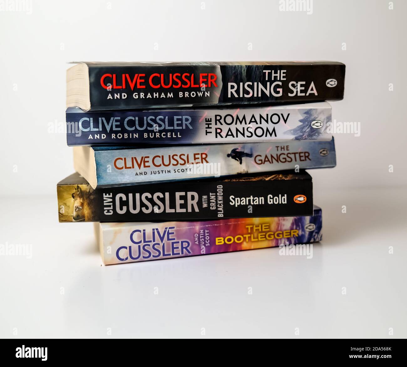 Norwich, Norfolk, Großbritannien – November 08 2020. Illustrative redaktionelle Foto einer Auswahl von Thriller Genre Taschenbuch Bücher von Clive Cussler isolat geschrieben Stockfoto