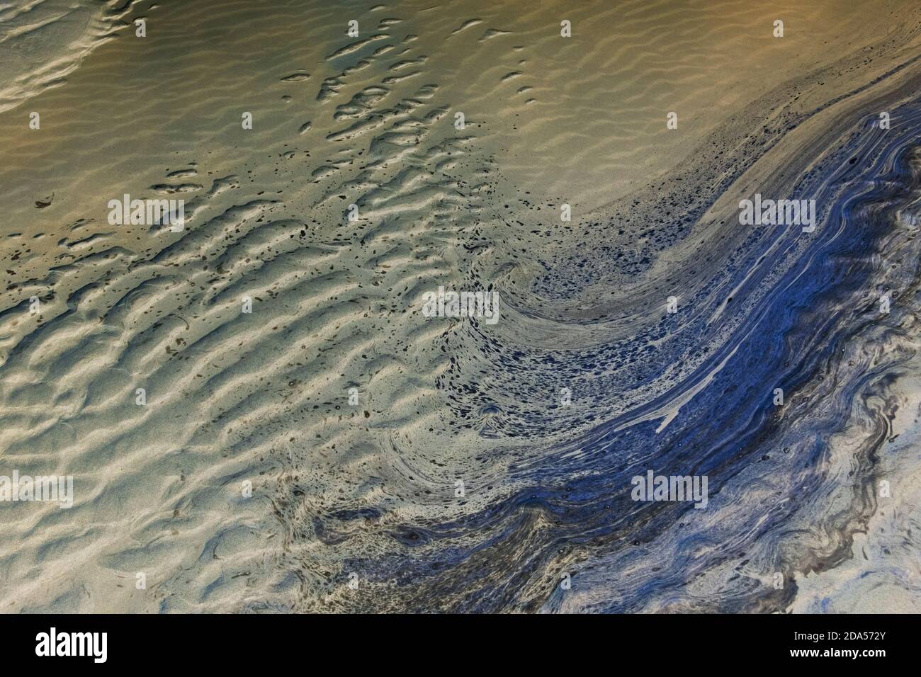 Ozeanwasser und Wellenmuster im Sand bei Ebbe. Stockfoto
