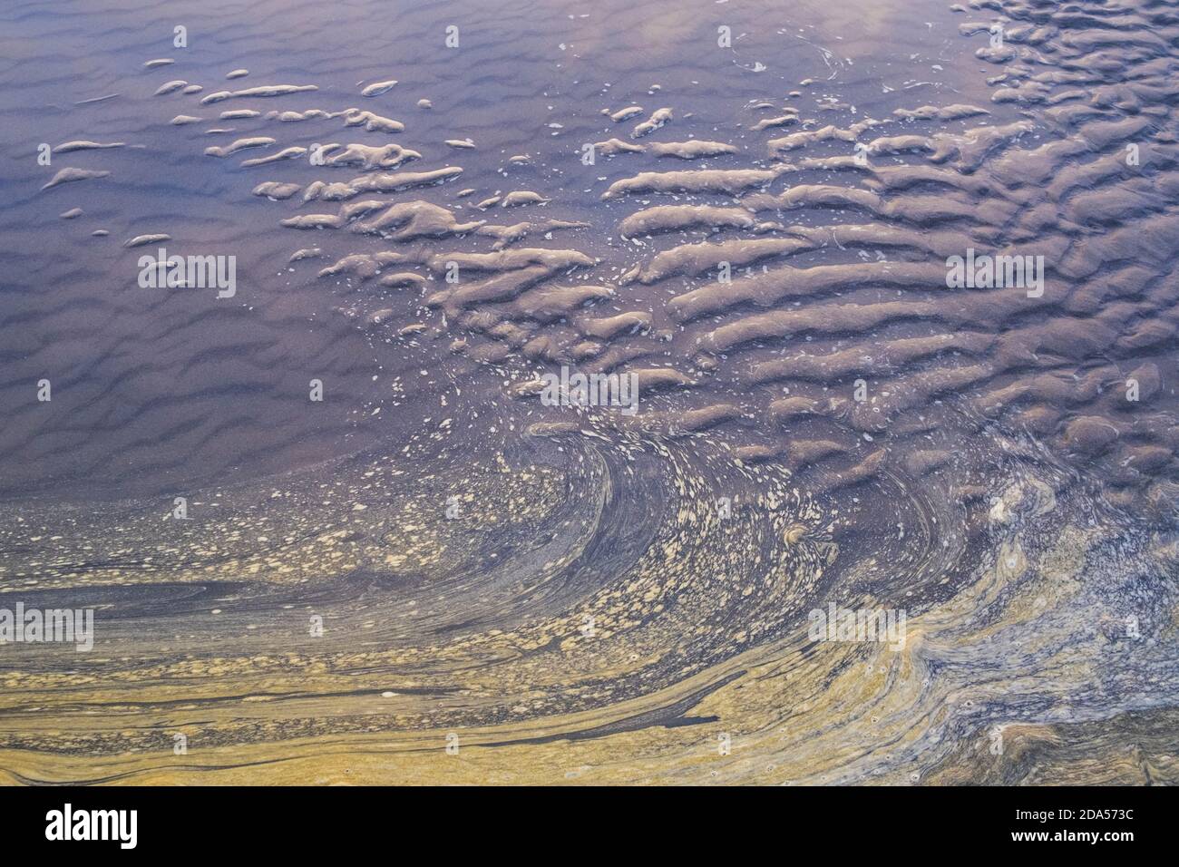 Ozeanwasser und Wellenmuster im Sand bei Ebbe. Stockfoto