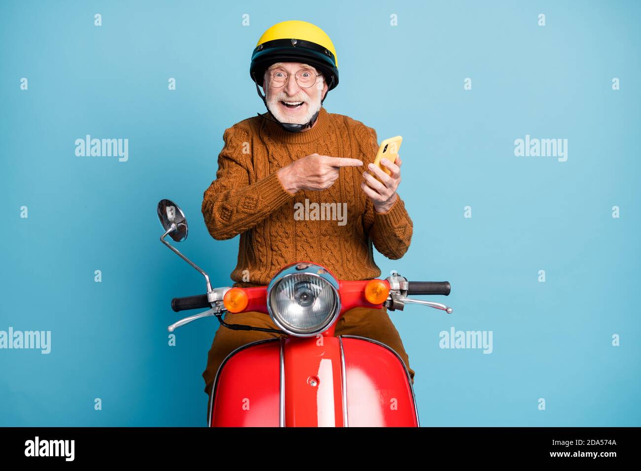 Porträt seiner er schön attraktiv fröhlich fröhlich froh bärtig Grauhaarige Mann Reiten Moped mit Demonstration Gerät Benachrichtigung isoliert über Stockfoto