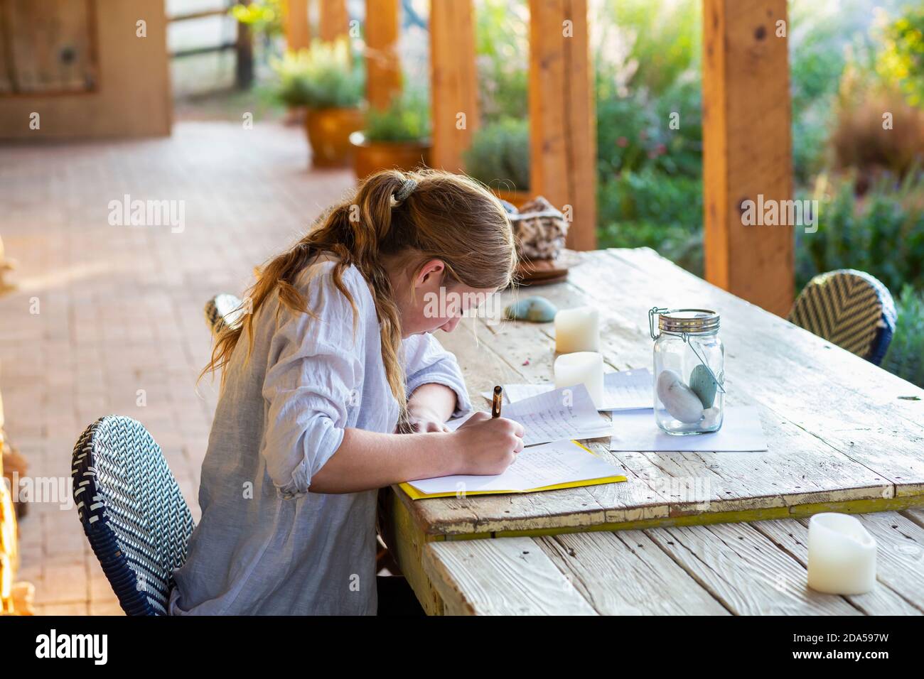 Teenager, die draußen auf der Terrasse bei Sonnenuntergang schreiben. Stockfoto