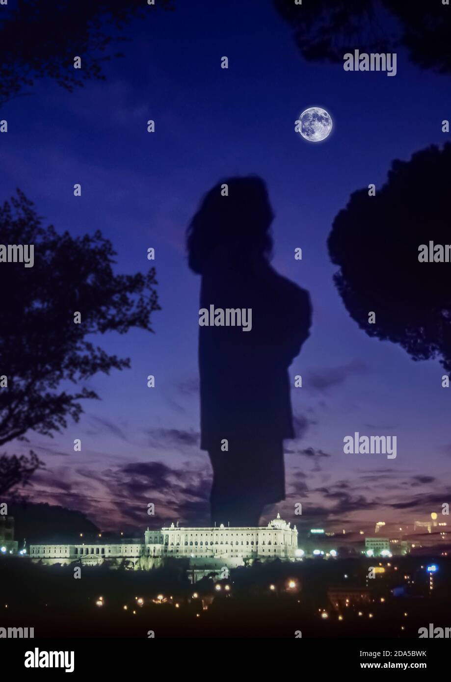 Silhouette einer Frau, die den Vollmond mit dem Palacio de Oriente in der Stadt Madrid, Hauptstadt Spaniens, Europa, betrachtet Stockfoto