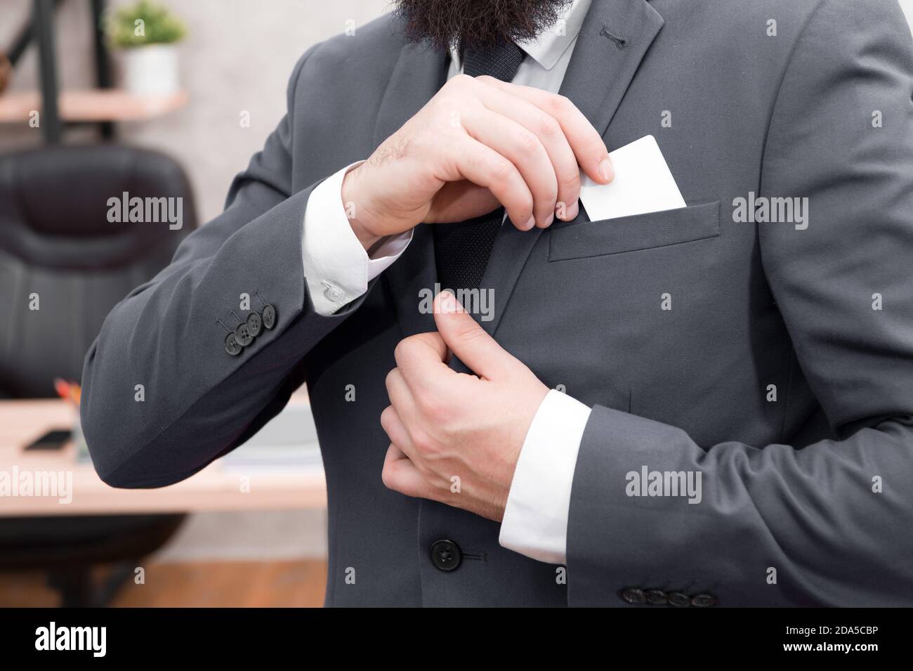 Business Card. Unternehmer setzen Karte im Anzug. Man. Moderne Geschäftsmann. Männliche Mode. Mann mit Kreditkarte. Nehmen Sie Platz in der Tasche. Hier ist meine Karte. Business Suit dress code. Stockfoto