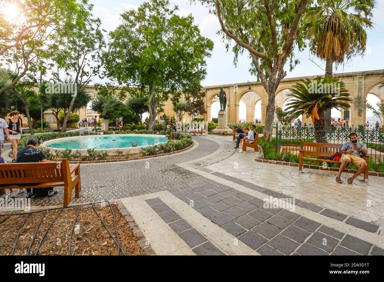Touristen rund um den Brunnen an der Upper Barrakka Gardens, einem öffentlichen Garten in Valletta, Malta. Stockfoto