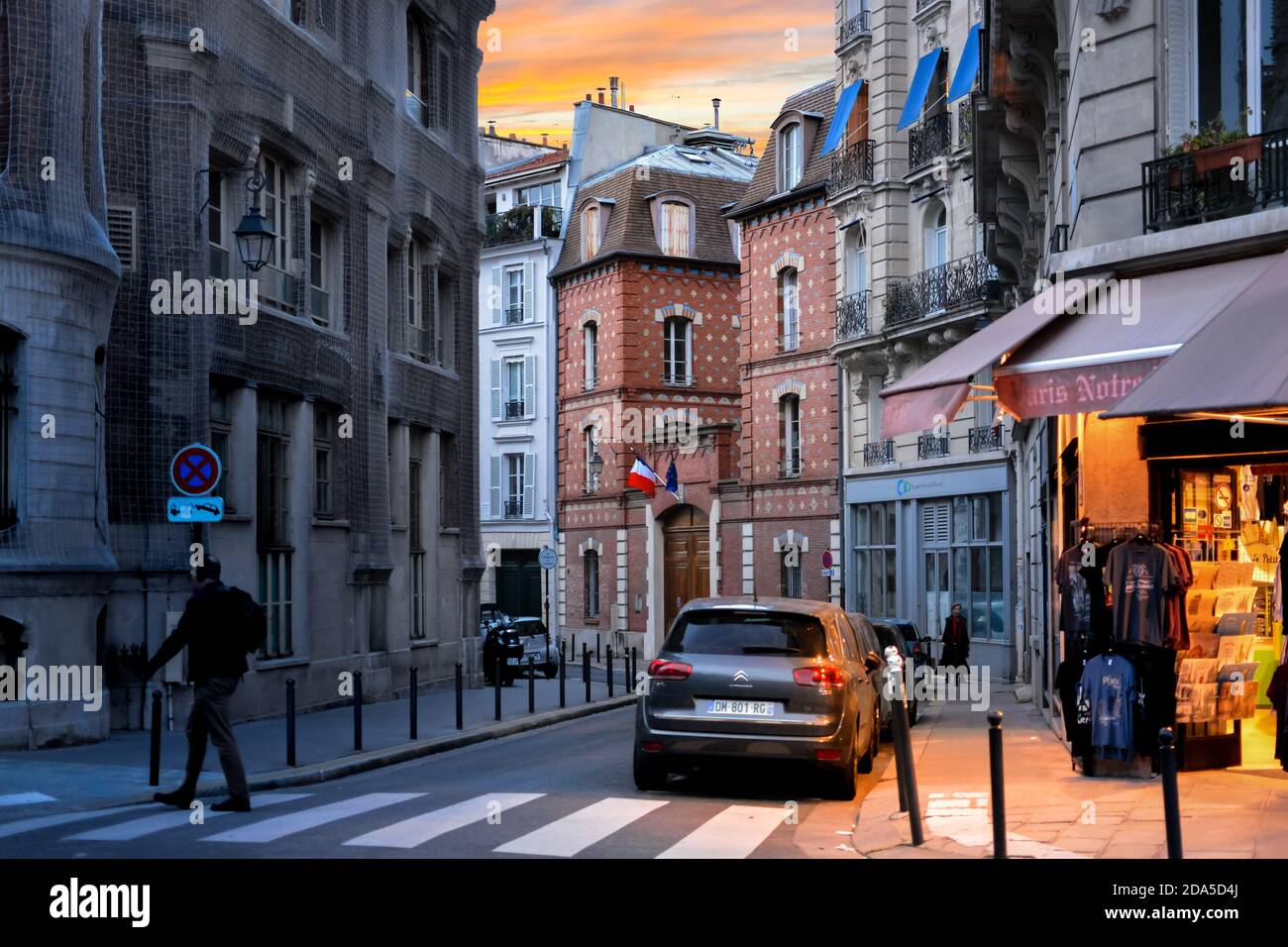 Eine schmale, malerischen Straße auf der Île de la Cité in Paris Frankreich als die Sonne untergeht und Licht von einem Souvenirshop glänzt auf dem Bürgersteig Stockfoto