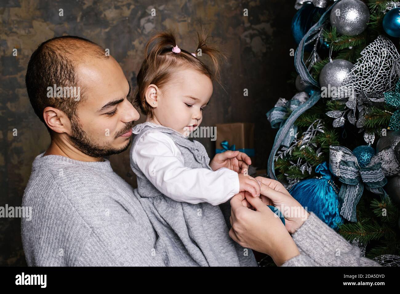 Glückliche Familie schmücken weihnachtsbaum zu Hause zusammen. Frohe Weihnachten und frohe Feiertage. Stockfoto