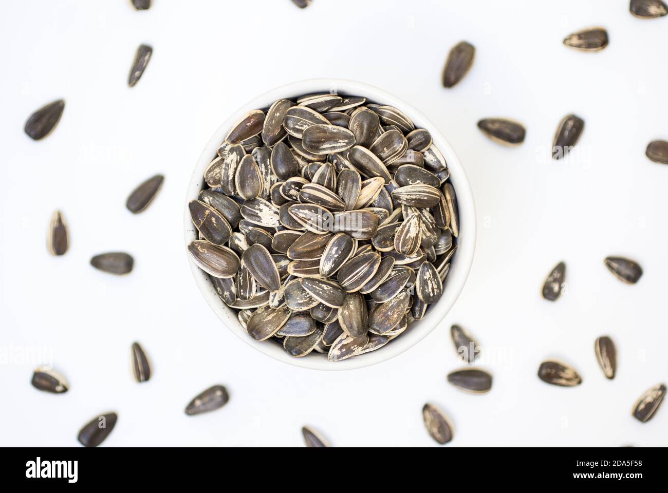 Sonnenblumenkerne auf einer Schüssel mit weißem Hintergrund. Gesundes vegetarisches Essen Stockfoto