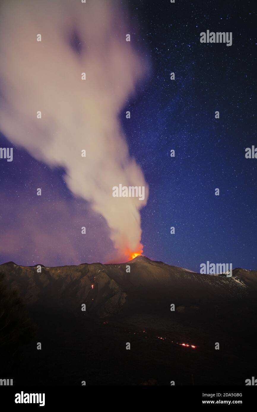 Rauch vom Vulkan Ätna während einer Eruption in der Nacht gegen Sternenhimmel, Sizilien Stockfoto