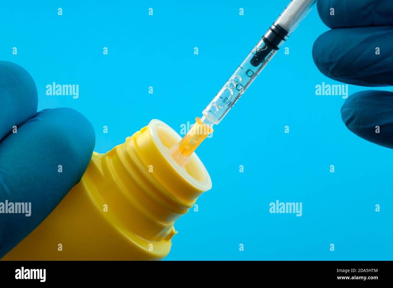 Bitte injizieren Sie Desinfektionsmittel Konzept nicht mit Arzt in blauen  Latexhandschuhe, Spritze und Chlorbleichflasche isoliert auf blauem  Hintergrund Stockfotografie - Alamy