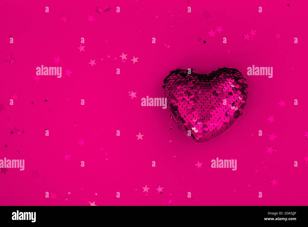 Weihnachts- oder Valentinskomposition aus glühender roter Herzdeko und Glitzer auf violetter Oberfläche. Frohe weihnachten und ein glückliches neues Jahr 2021 Stockfoto