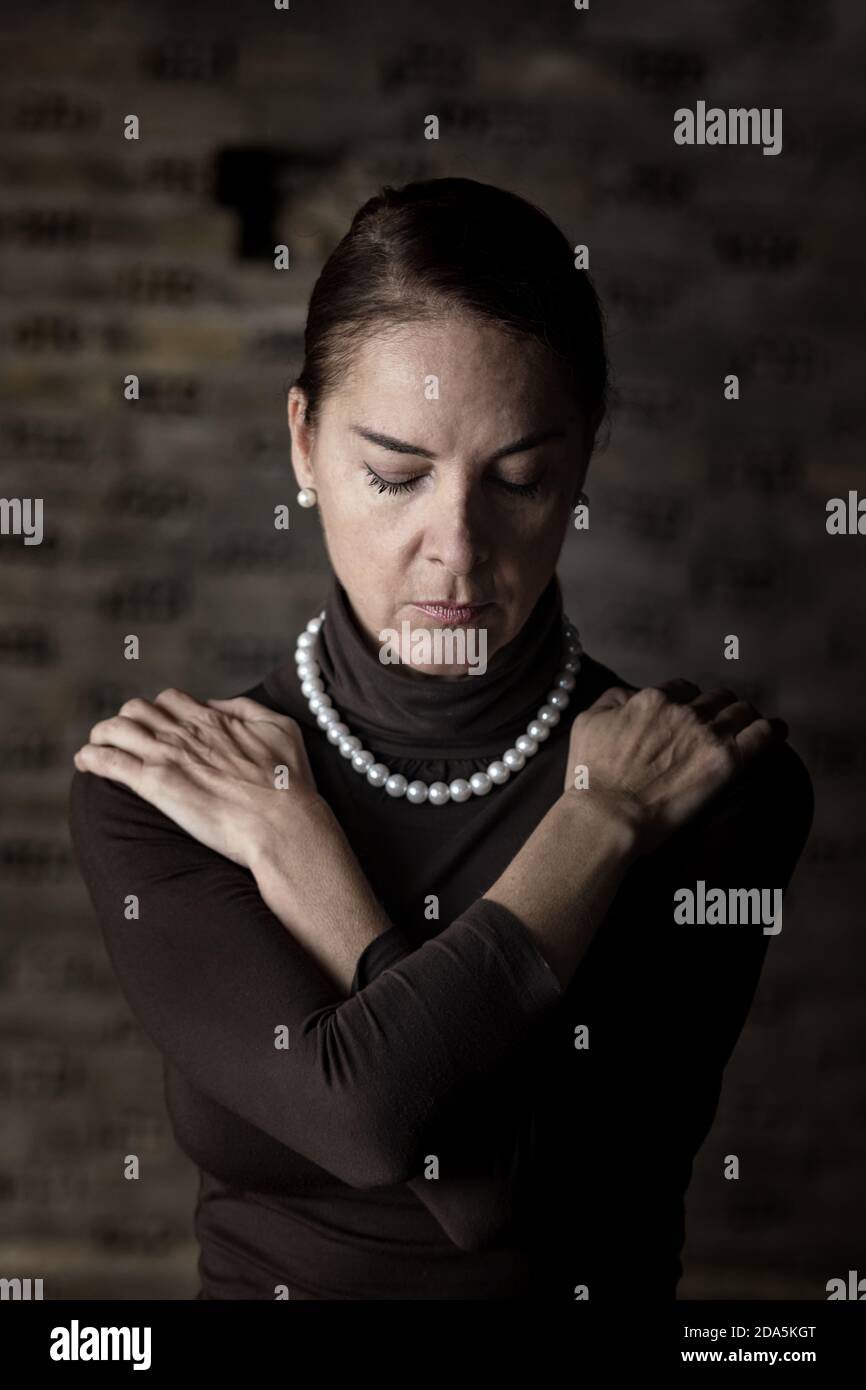 Porträt einer Frau mit über ihre Brust gekreuzten Armen. Stockfoto