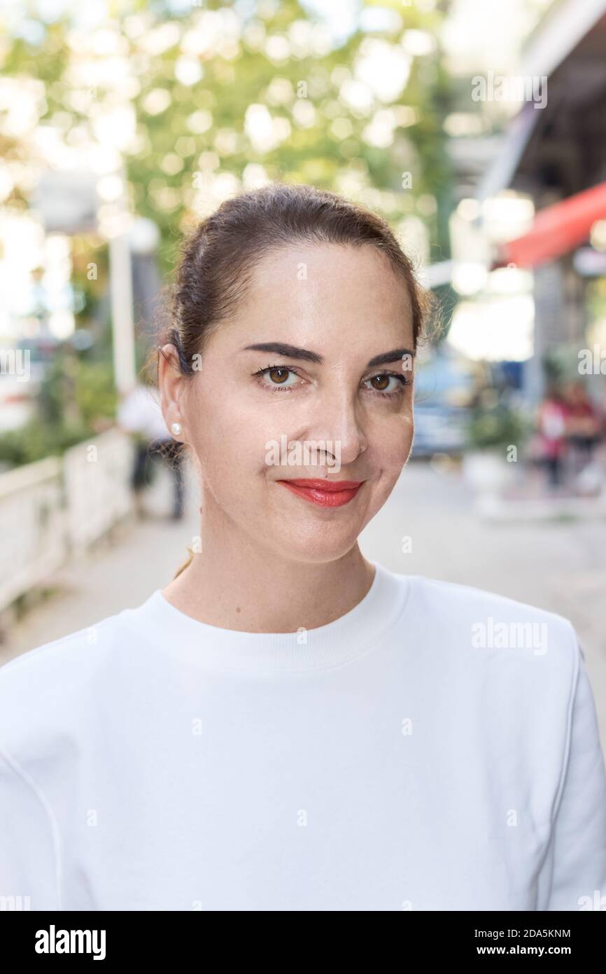 Porträt einer Frau mit updo Haar, lässig, natürlichen Look, schlank, im Freien, weiches Lächeln Stockfoto