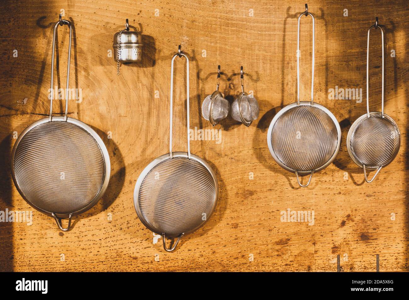 Set aus Metall-Mesh-Siebe auf Holzhintergrund hängen Stockfoto