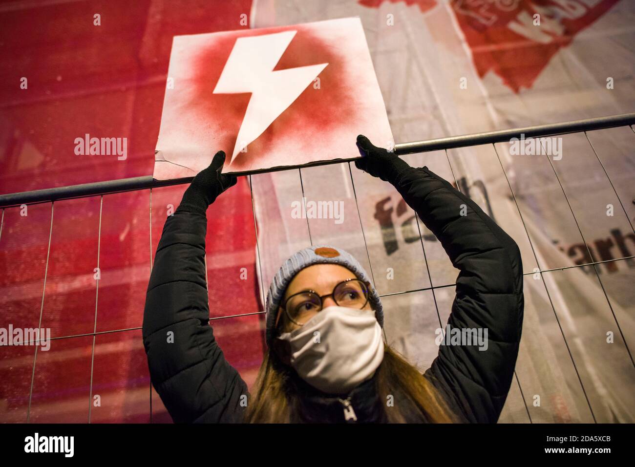 Ein Protestler mit Gesichtsmaske hält ein Plakat mit dem Symbol des Frauenwiderstands, dem roten Blitz während der Demonstration.die Gegner des Urteils des Verfassungsgerichts über Abtreibung protestierten erneut. Hunderte von Menschen versammelten sich vor dem Ministerium für Bildung, um den Rücktritt des Ministers für Bildung und Wissenschaft, Przemyslaw Czarnek, zu fordern, der für seine homophoben und chauvinistischen öffentlichen Äußerungen bekannt ist. Bei mehreren Gelegenheiten zerstreute die Polizei gewaltsam Demonstranten, die versucht hatten, den Verkehr zu blockieren und unerwartet durch das Stadtzentrum marschierten. Zahlreich Stockfoto