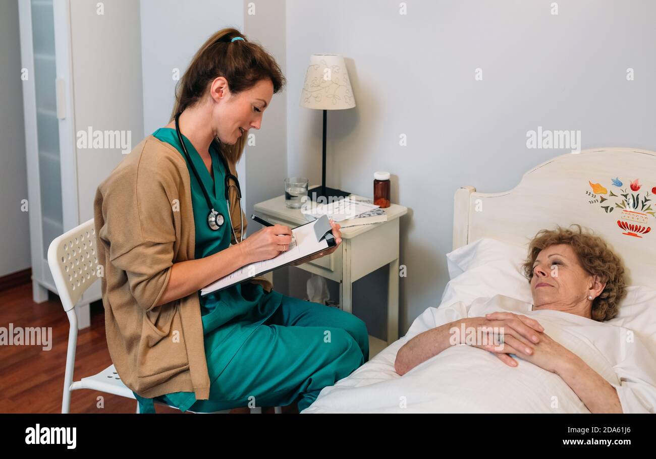 Ärztin Ausfüllen eines Fragebogens Stockfoto