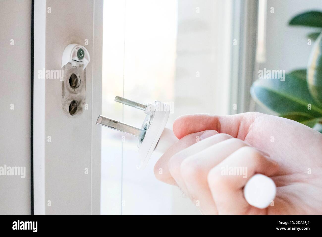 Der Fenstergriff ist kaputt. Halten Sie den Mechanismus in der Hand. Stockfoto