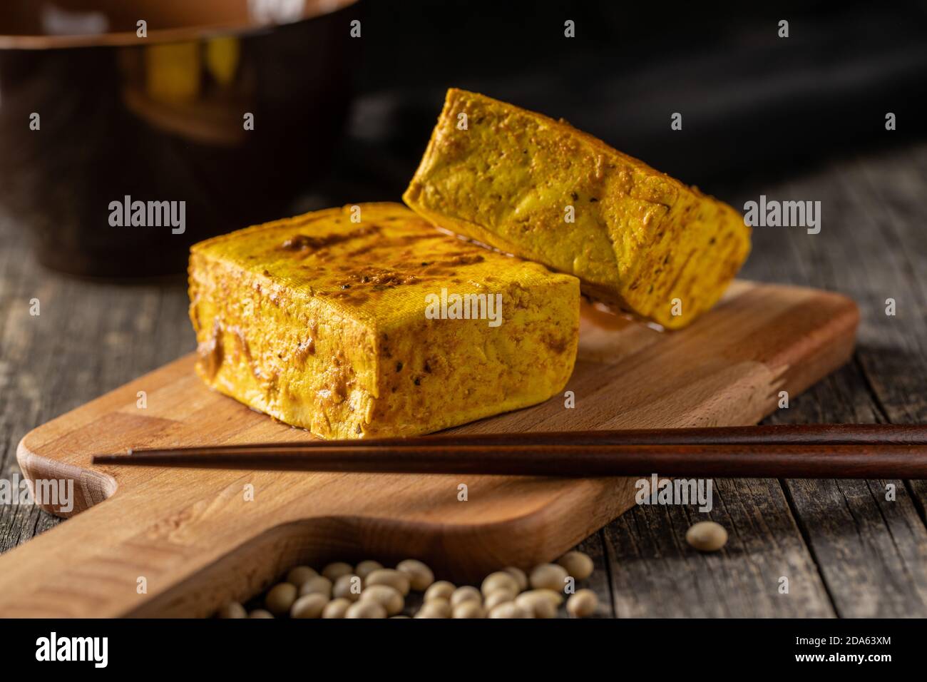 Würfel marinierter Tofu auf Schneidebrett. Stockfoto