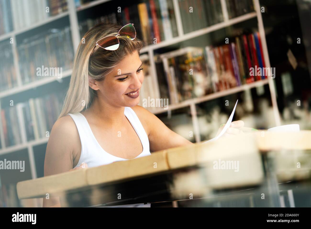 Schönes Studenten-Mädchen, das zu Hause studiert und Buch liest Stockfoto