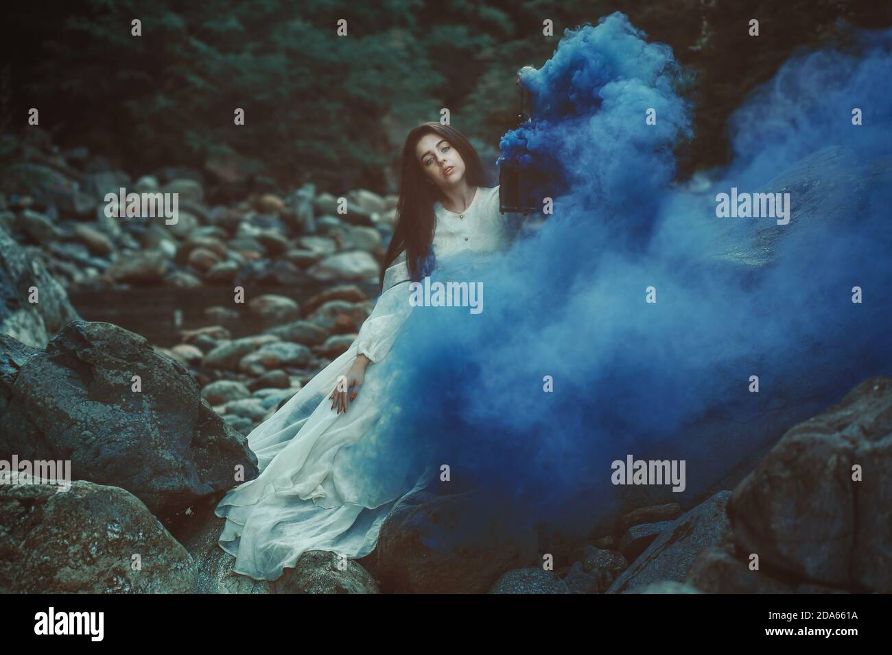 Schöne Frau unter blauem Rauch Stockfoto