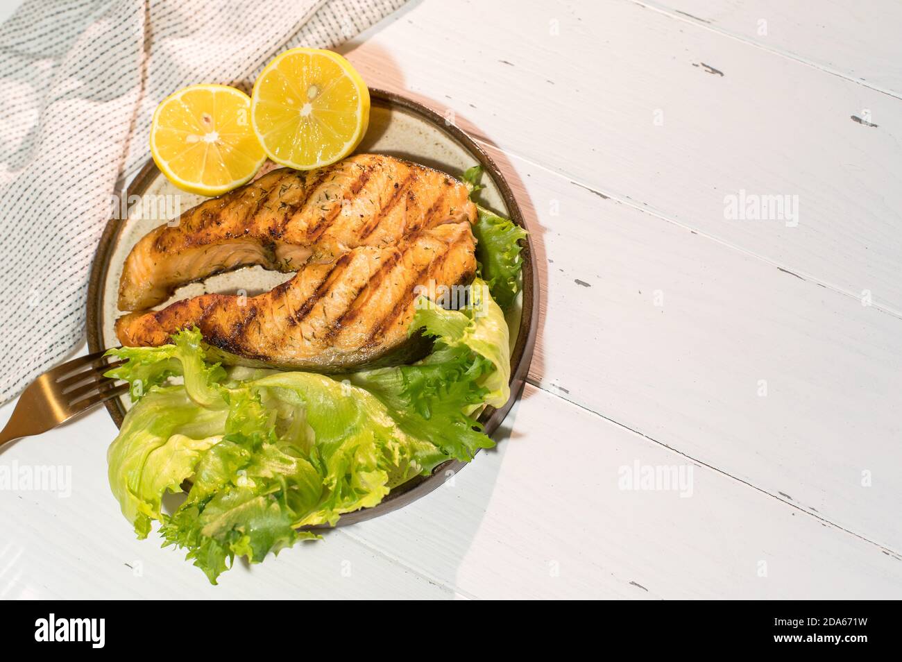 Teller gegrilltes Lachssteak mit Salat auf Holztisch Stockfoto