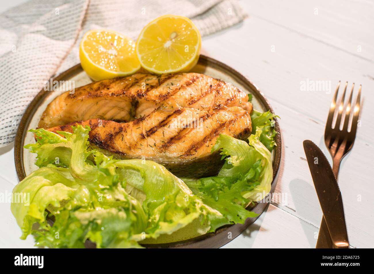 Teller gegrilltes Lachssteak mit Salat auf Holztisch Stockfoto