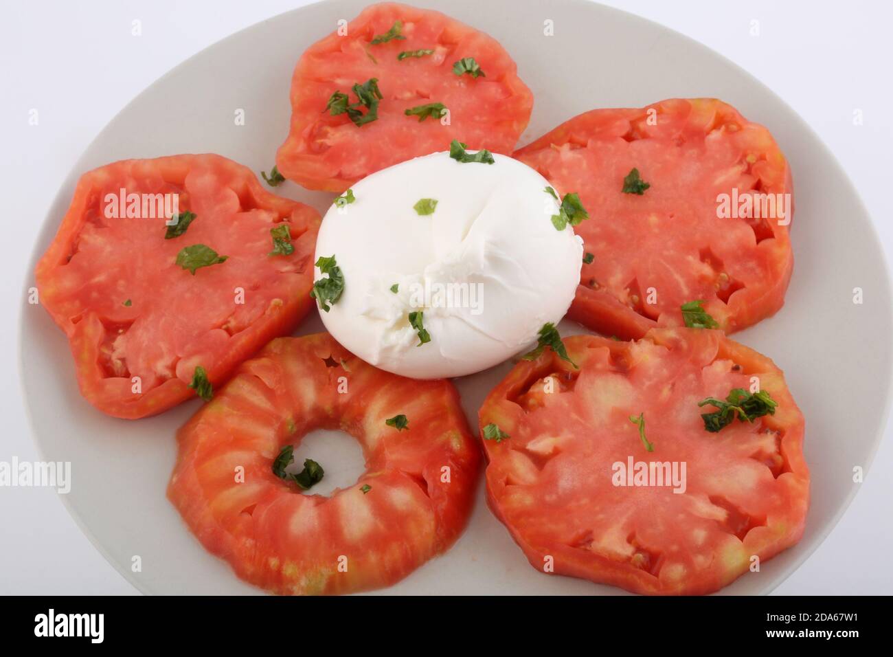 Salat aus Tomaten und Mozarella mit Basilikumblättern Stockfoto