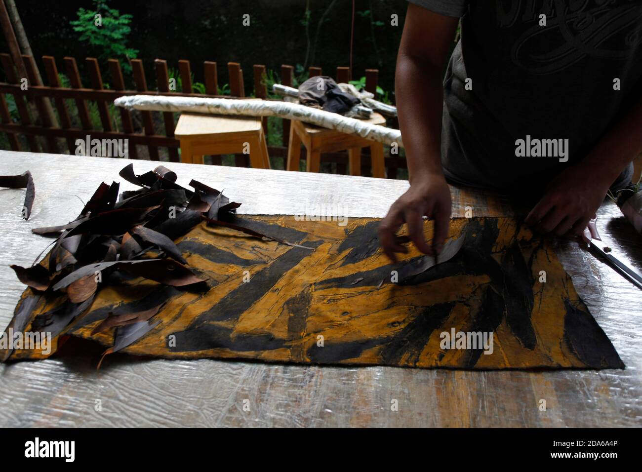 Bogor, Indonesien. November 2020. Am 9. November 2020 wird ein Handwerker in der Arae Produktionsgalerie in Bogor City, West Java, Indonesien, gesehen, wie er trockene Holzblätter auf dem Stoff schält, während er die Öko-Drucktechnik anwendet. Eco-Printing ist eine Technik, mit der Pflanzen, Blätter und Blumen ihre Formen, Farben und Markierungen auf Stoff für einen der umweltfreundlichen Modetrends hinterlassen. (Foto von Adrian/INA Photo Agency/Sipa USA) Quelle: SIPA USA/Alamy Live News Stockfoto