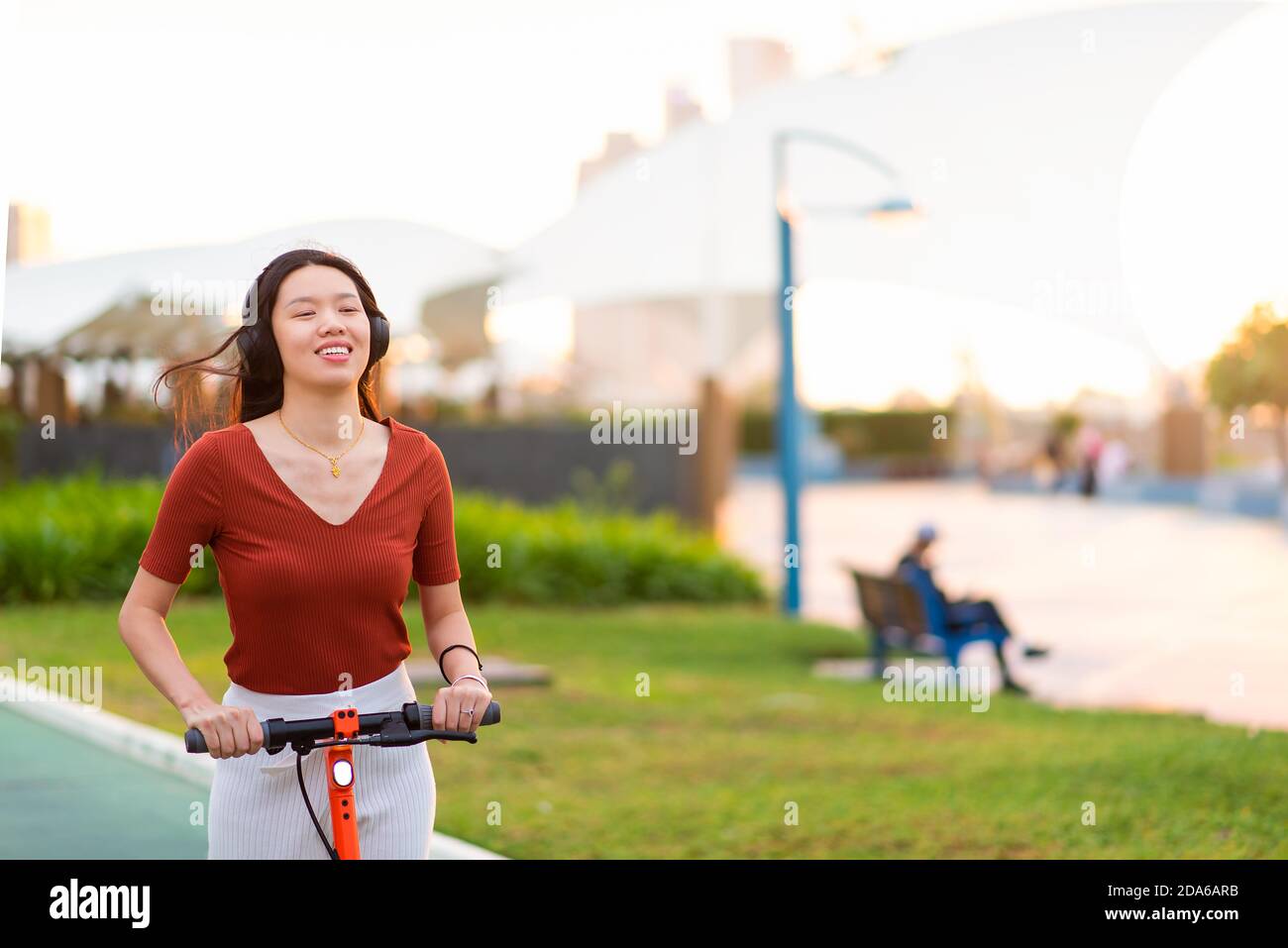 Frau mit einer Fahrt auf Elektroroller für schnelle und Einfache Verkehrsanbindung in einem modernen Stadtleben Stockfoto