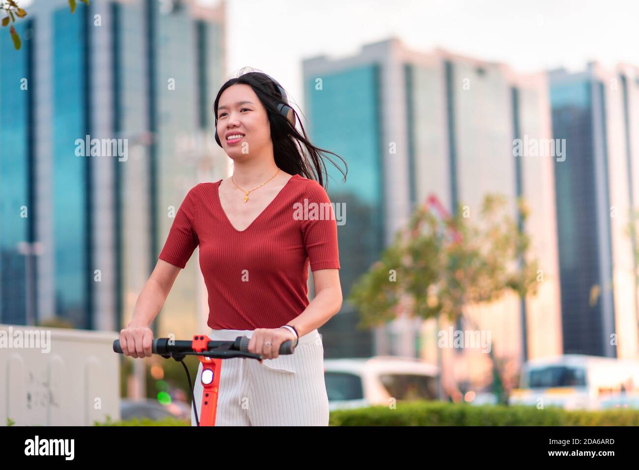 Frau mit einer Fahrt auf Elektroroller für schnelle und Einfache Verkehrsanbindung in einem modernen Stadtleben Stockfoto