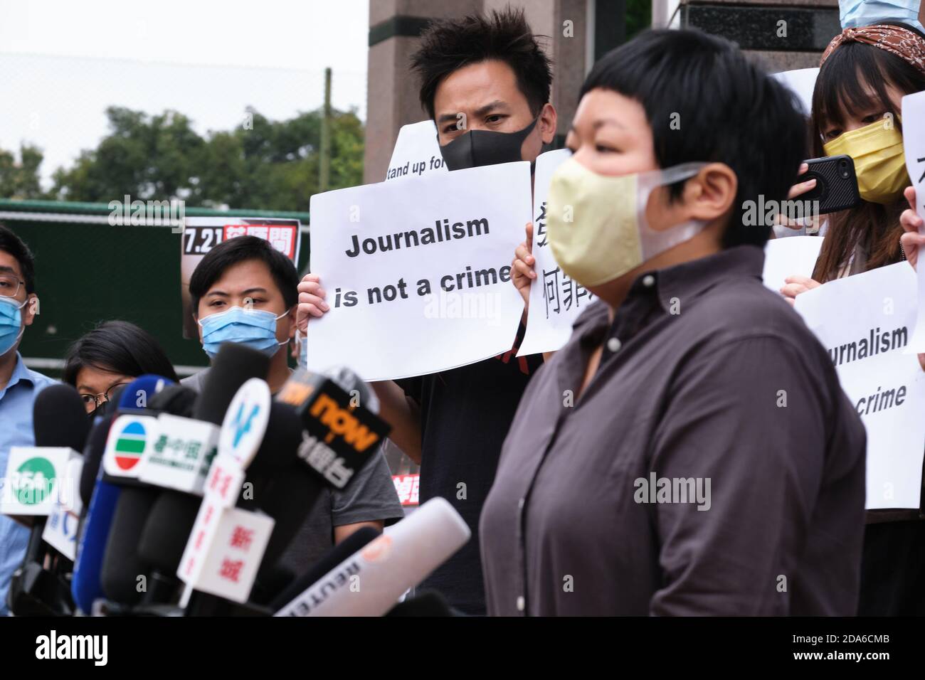 Ein Unterstützer hält ein Plakat mit der Aufschrift "Journalist is not a crime", während Bao Choy-yuk Ling, ein freier Journalist, vor dem Fanling Magistrate Court zu einer Anhörung zu den Medien spricht.Bao Choy-yuk Ling, ein freiberuflicher Journalist, der mit Hongkongs öffentlich-rechtlicher Rundfunkanstalt RTHK (Radio Television Hong Kong) arbeitete. Bei den Ermittlungen zum Yuen Long-Mobangriff vom Juli 21 kommt das Gericht der Magistraten von Fanling mit einem Gesichtsbefrag zu einer Anhörung an. Choy wurde verhaftet, weil sie eine falsche Aussage über ihre Untersuchung von Verdächtigen gemacht hatte, die an dem Yuen Long-Mobangriff für eine RTHK-TV-Dokumentation beteiligt waren. Stockfoto