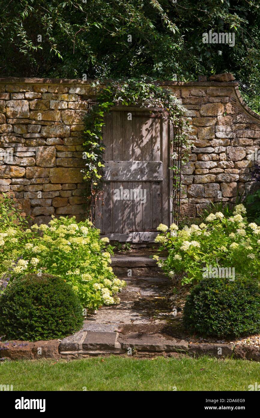 Hölzerne Tür in Steinmauer im Englischen Garten, England, Europa Stockfoto