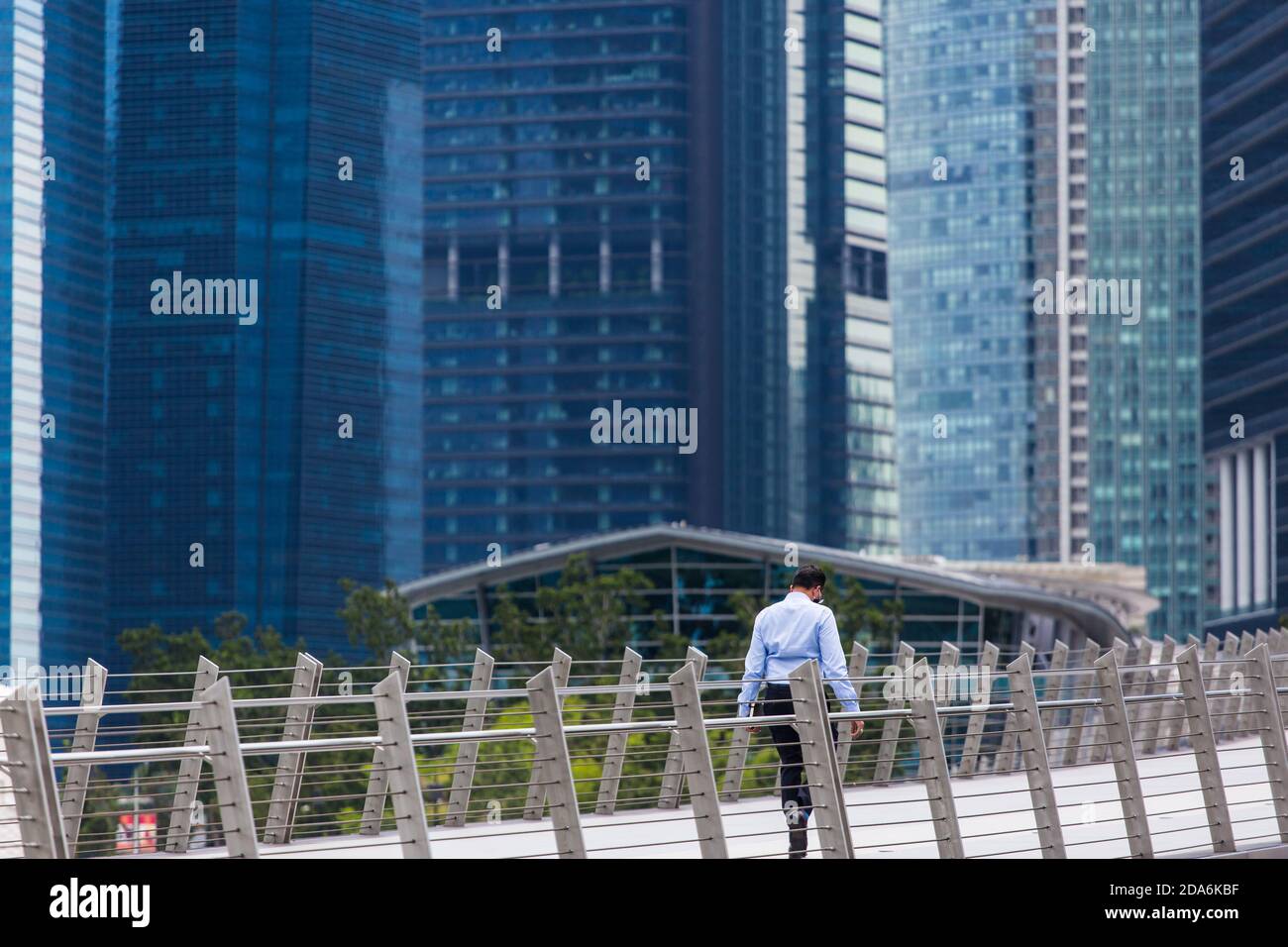 Rückansicht eines professionellen Büroangestellten, der auf der Brücke nach unten schaut, Singapur. 2020 Stockfoto