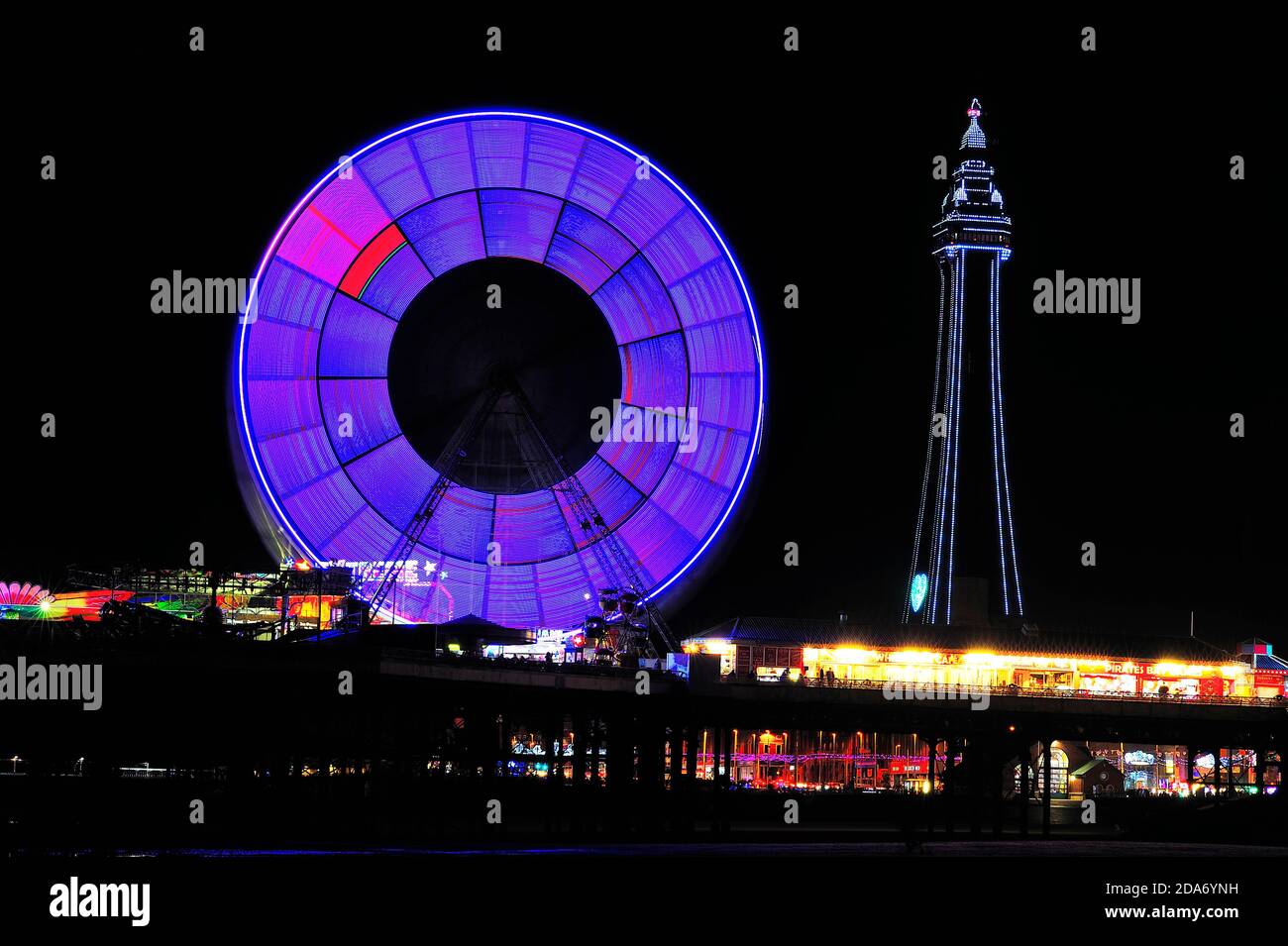 Die vielen Farben des Blackpool Tower und das Riesenrad Nachts während der jährlichen Beleuchtung Stockfoto