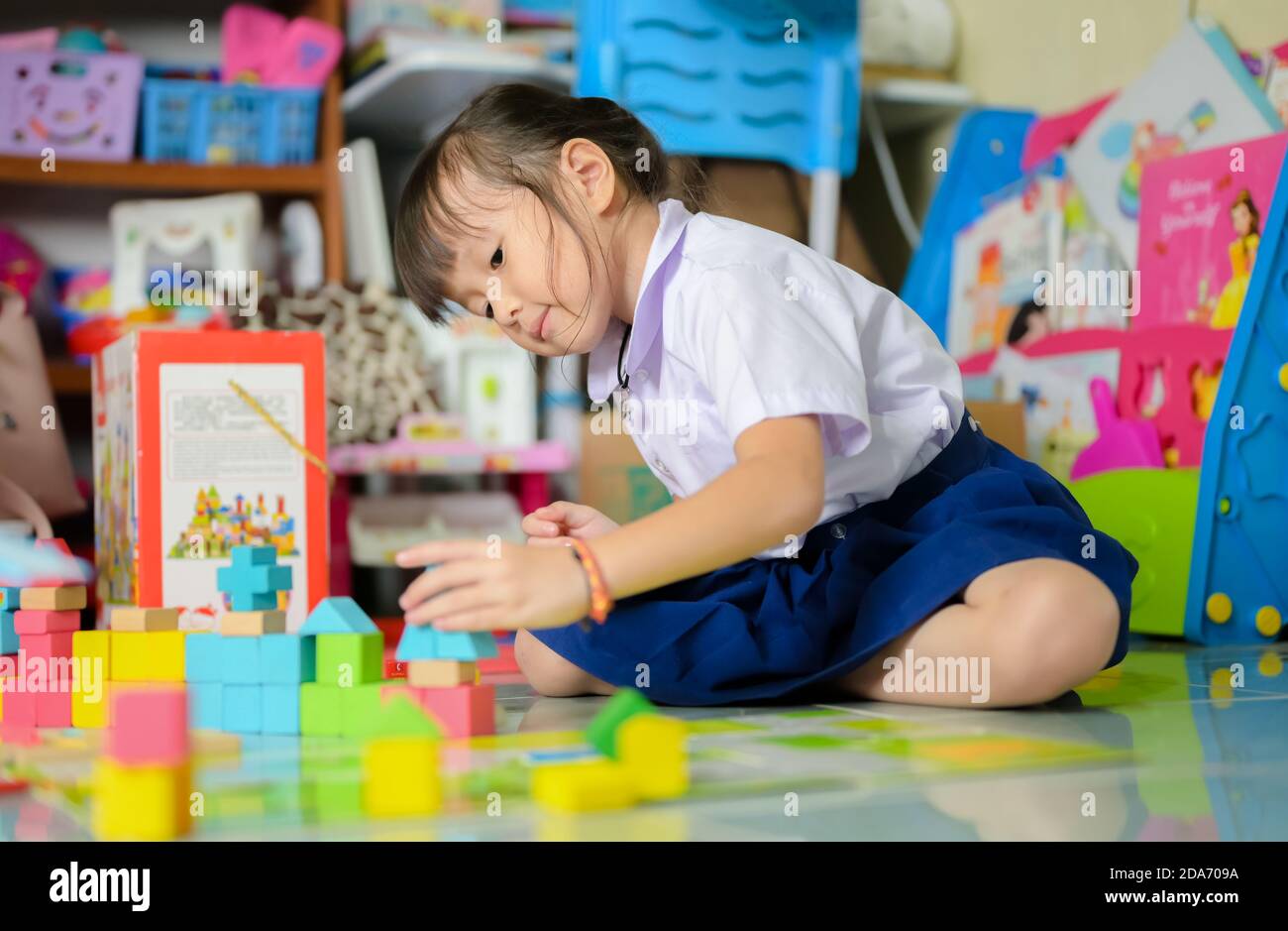 Kind kleines Mädchen spielen Holzblock Spielzeug im Wohnzimmer Für Entwickler steigern Sie Kreativität und Phantasie Stockfoto