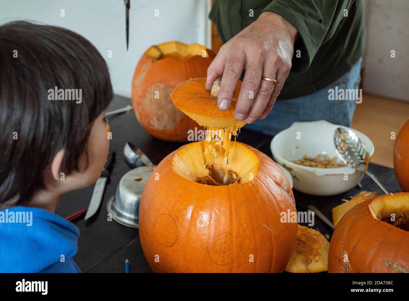 Sheffield UK – Oktober 30 2019 : Halloween-Vorbereitungen als Papa und die Kinder damit beschäftigt sind, die Jack O Lanterns zu schnitzen Stockfoto