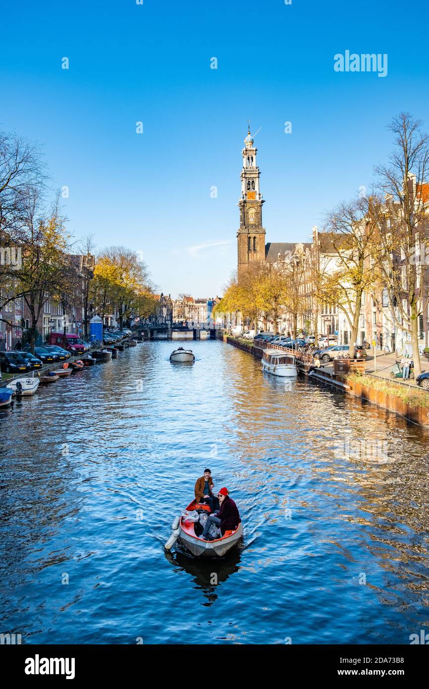 Amsterdam Niederlande während der Herbstsaison in der Stadt neben Die niederländischen Kanäle mit bunten Bäumen rund um die Kanäle und Leute, die sich entspannen Stockfoto