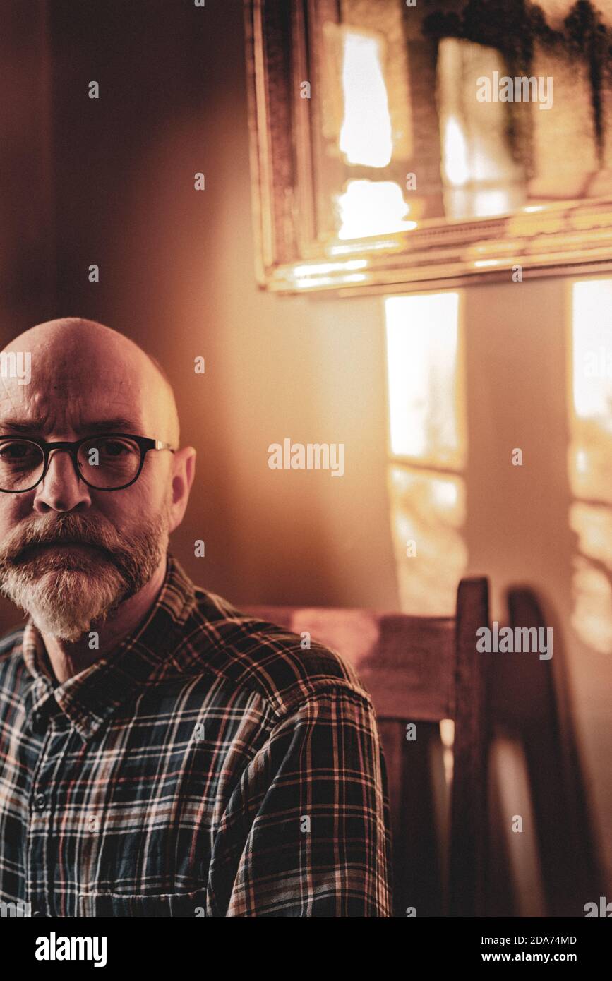 Sitzendes Porträt des Fotografen ein Mann mittleren Alters trägt Brille mit Bart Stockfoto