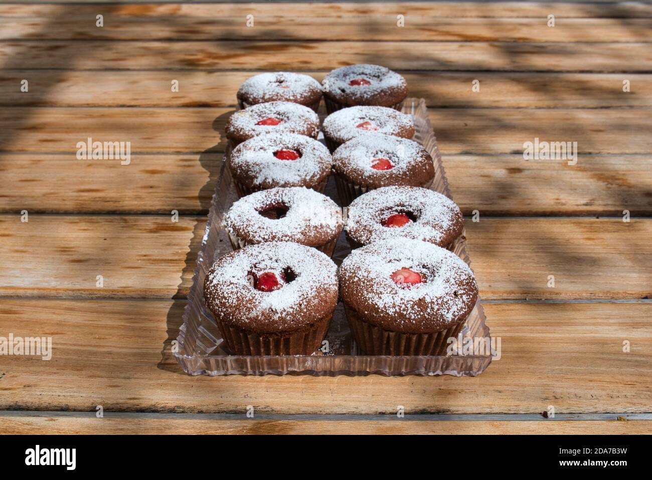 Frisch gebackene hausgemachte Cupcake-Desserts mit Obstzentrum auf dem Tisch im Freien. Weitwinkelansicht. Stockfoto