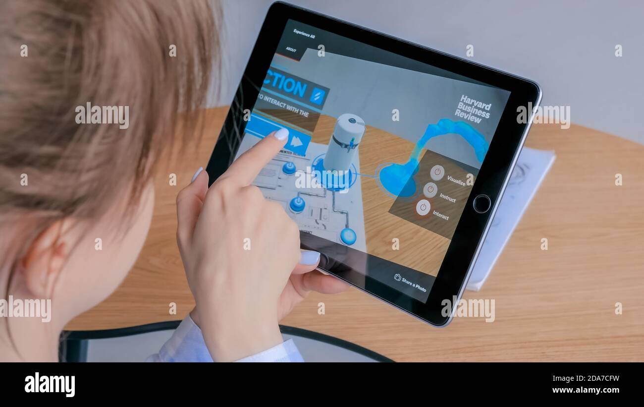 MOSKAU, RUSSLAND - 1. AUGUST 2019. Frau mit Tablet mit Augmented Reality App - virtuelles 3d-Modell des robotisierten Produktionsmoduls. AR, Produktion Stockfoto