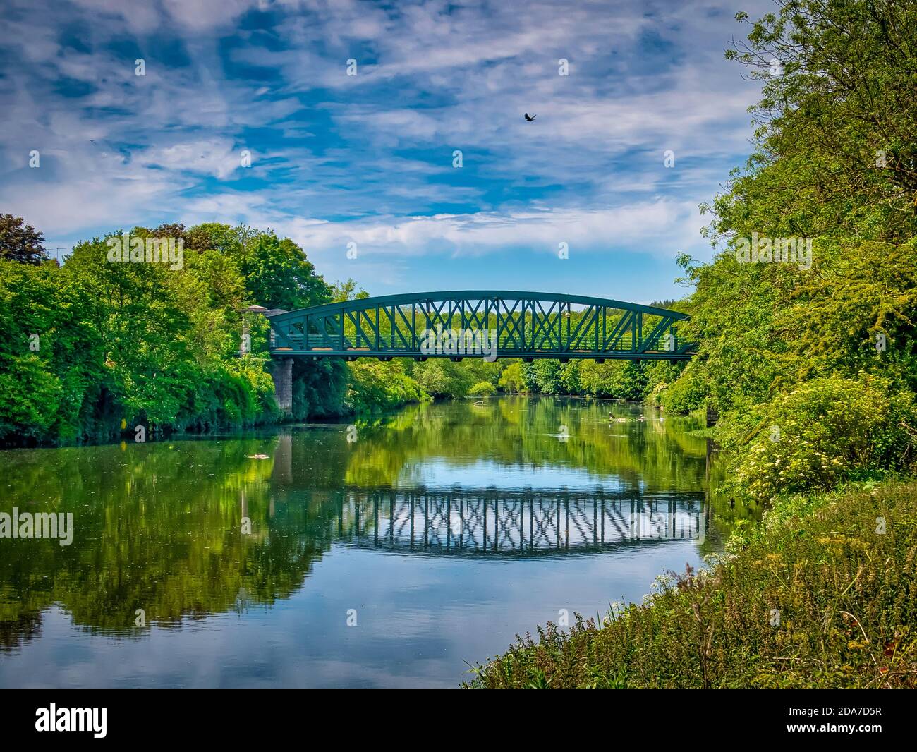 Ein wunderschöner Sommertag in Washington, Großbritannien mit Blick auf die Fatfield Bridge, die sich in der River Wear mit einer Krähe über dem Wasser spiegelt. Stockfoto