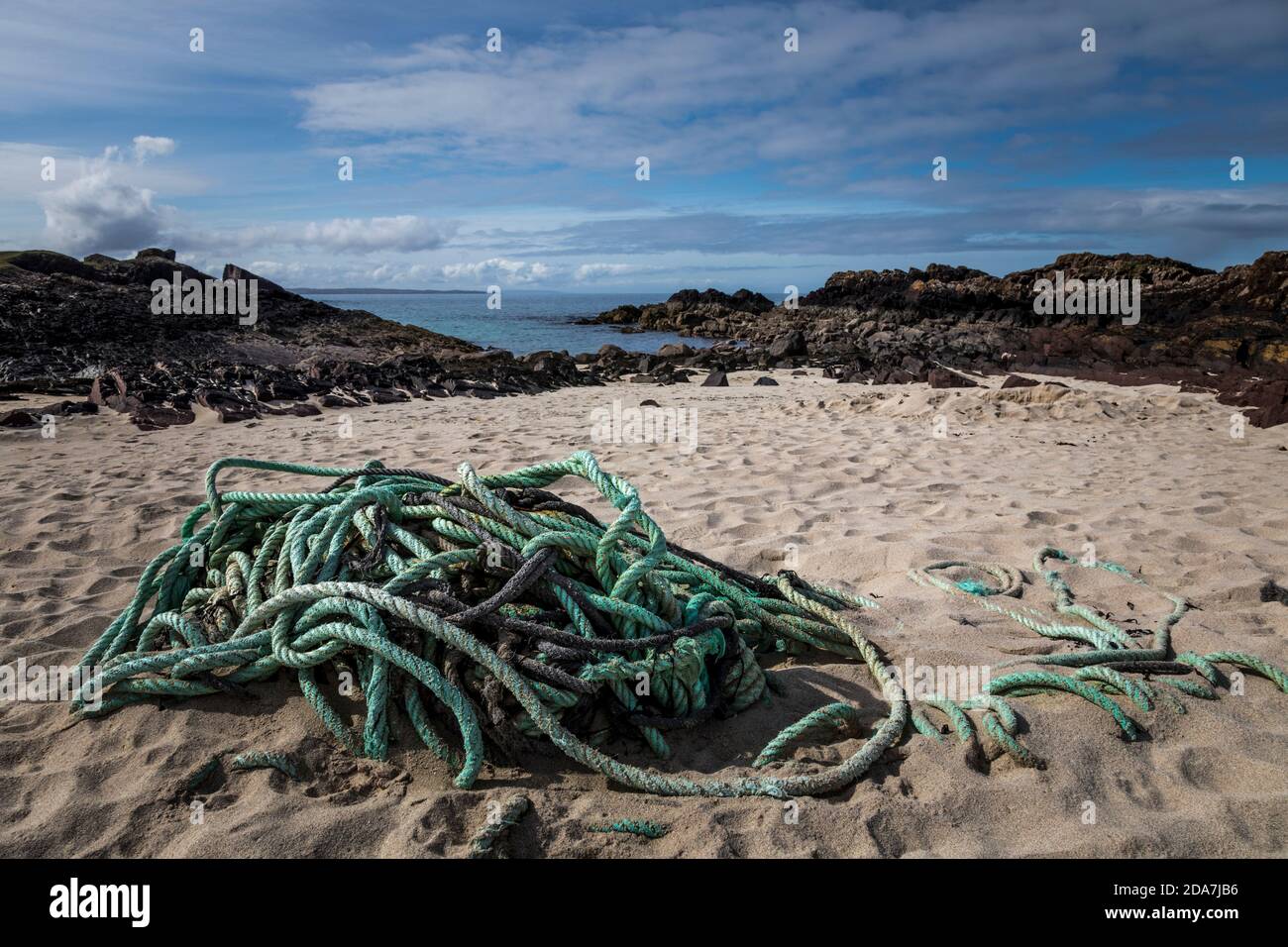 Grünes Nylonseil an einem Sandstrand in Clachtoll, Schottland aufgegeben. Stockfoto