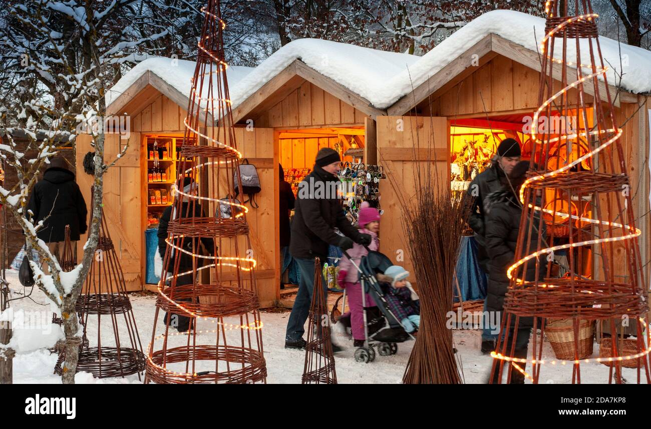 Ettal, Deutschland/Bayern – 31. Dezember 2019: Verschneite Weihnachtsmärkte mit beleuchteten Geschäften in Holzhütten mit Geschenken und handgefertigter Dekoration. Stockfoto