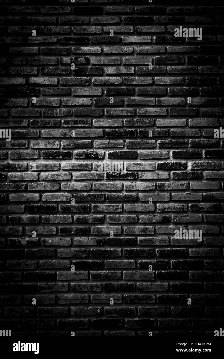 Schwarze Ziegelwände, die nicht verputzt Hintergrund und Textur. Die Textur des Ziegels ist schwarz. Hintergrund der leeren Backsteinkeller Wand. Stockfoto