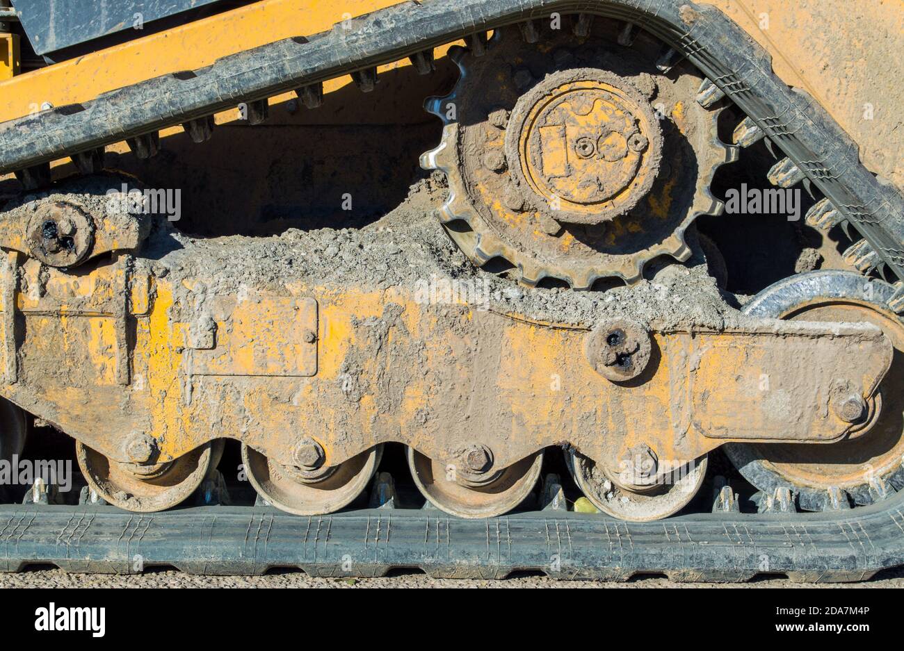 Nahaufnahme der Schlamm gekackten Unterwagen und Spur von A Kleine Planierraupe auf einer Baustelle Stockfoto