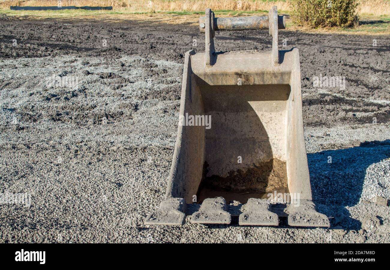 Eine leere freistehende schwere Bulldozer Eimer sitzen in der Schmutz auf einer Baustelle mit Kopierplatz Stockfoto