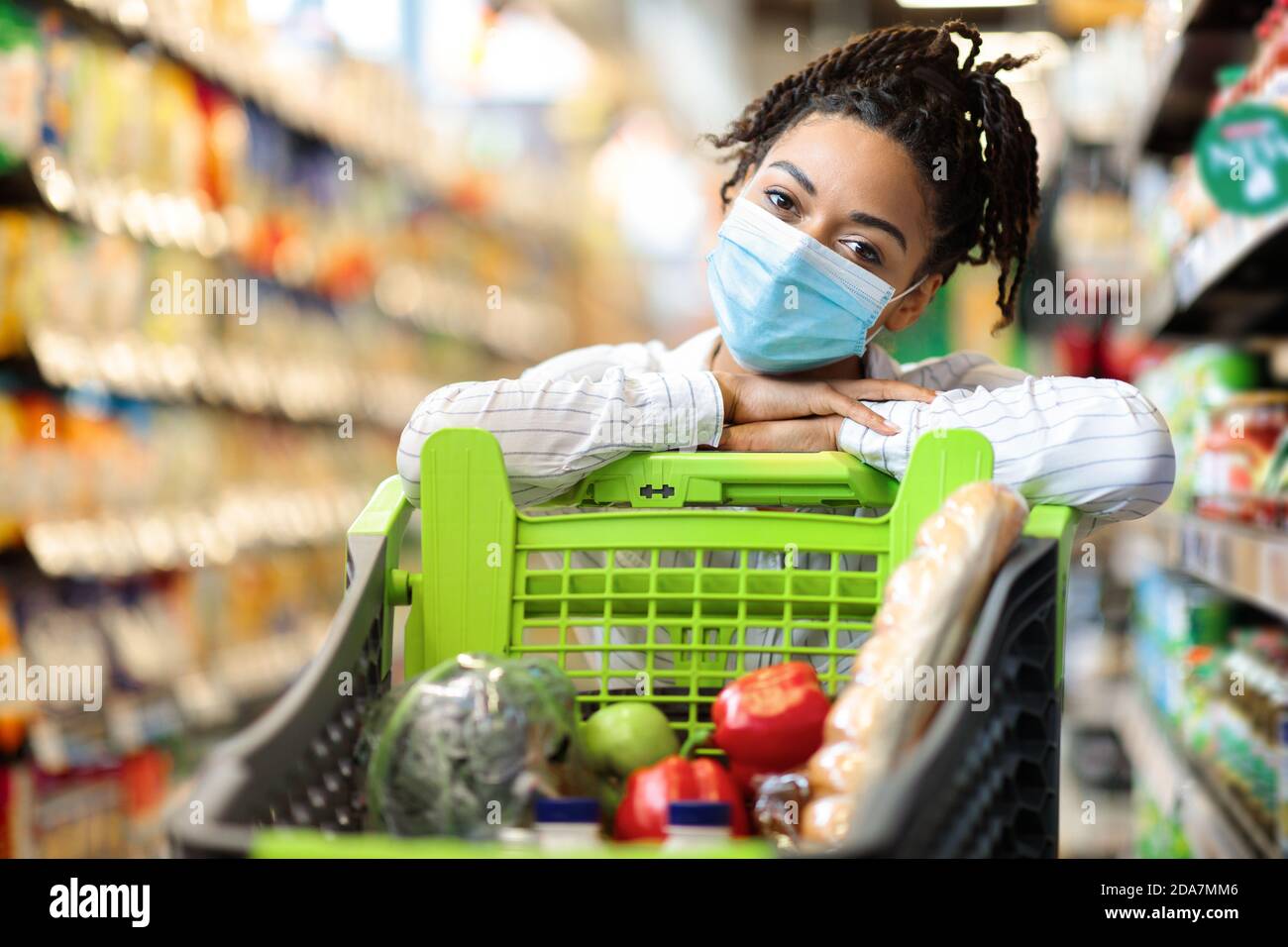 Frau Posiert Mit Einkaufswagen Voller Lebensmittel Im Supermarkt Stockfoto