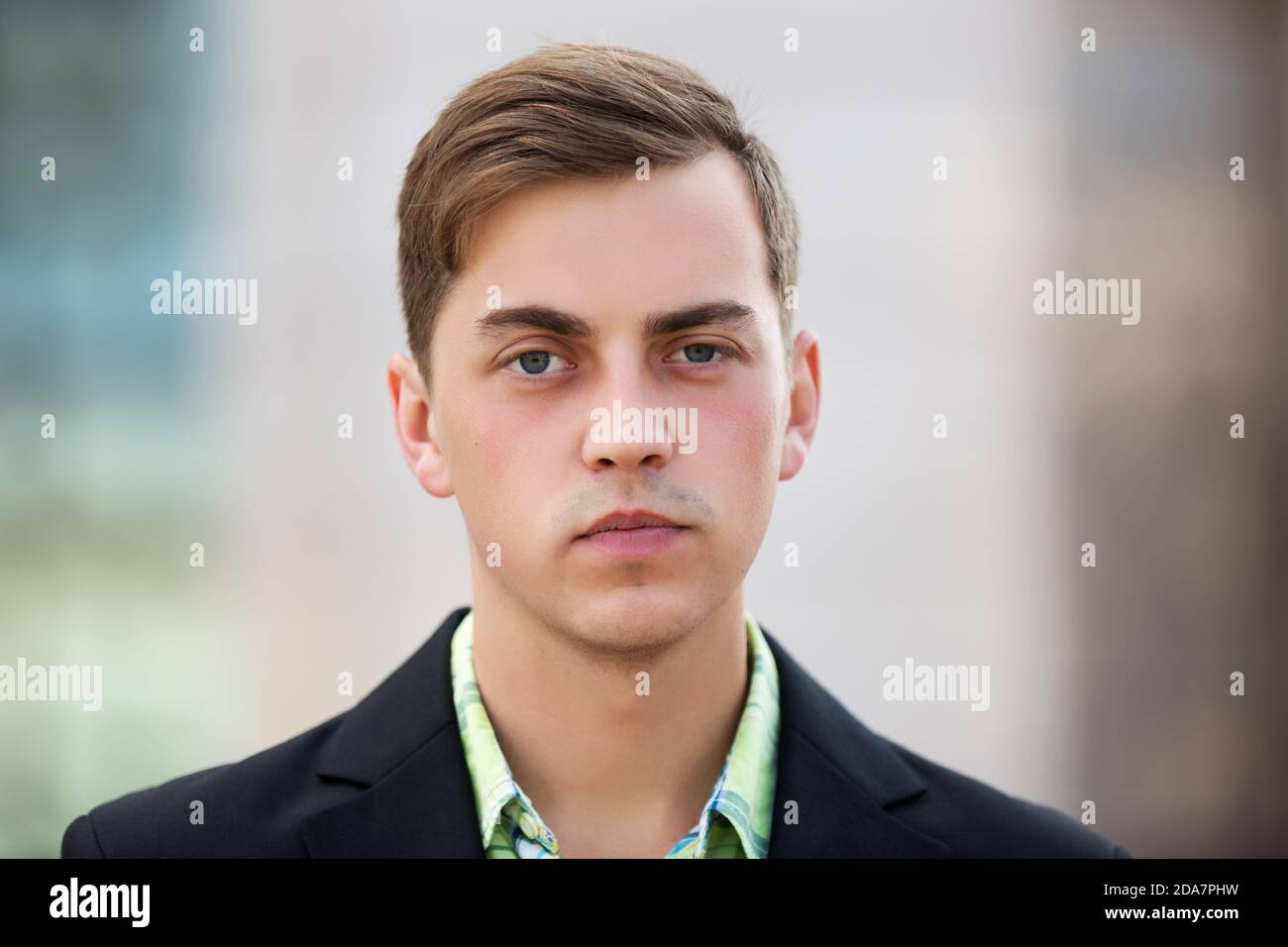 Junger, hübscher Mann in schwarzem Blazer, der auf der Stadtstraße läuft Stockfoto